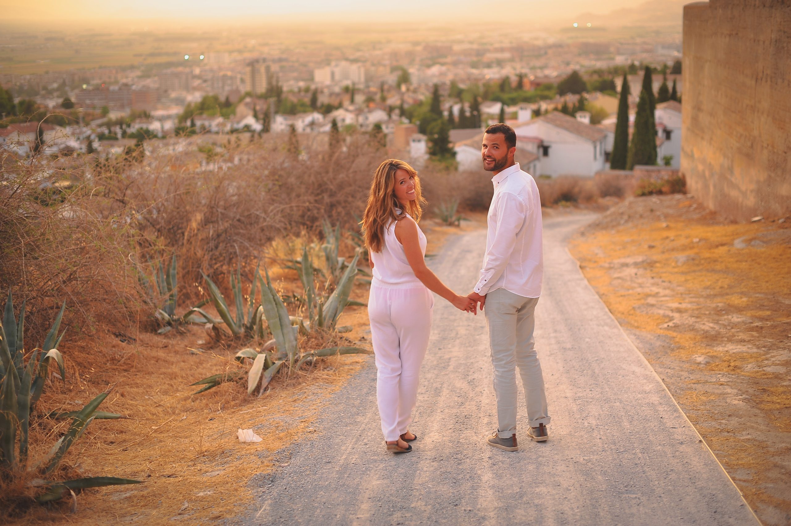 retrato-de-una-feliz-pareja-de-jovenes-de-pie-en-la-carretera-en-la-colina